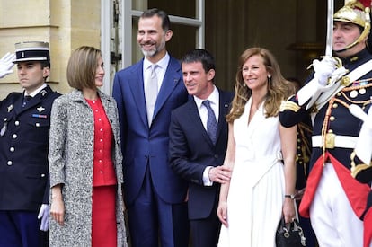 Letizia, con un abrigo negro y blanco sobre un conjunto rojo, con el Rey, el primer ministro Manuel Valls y su esposa Anne Gravoin.