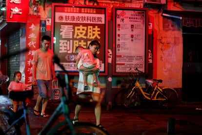 Una familia camina de noche en el centro de Guanghzou.