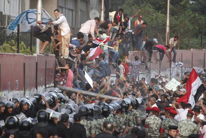 Centenares de personas tratan de derribar el muro que protege la embajada de Israel en El Cairo.