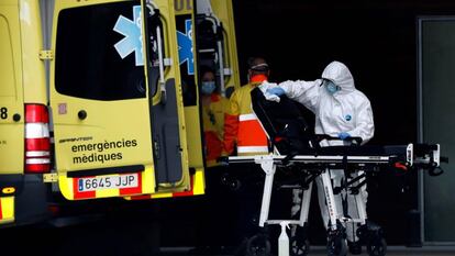 Un técnico sanitario desinfecta la camilla de una ambulancia en la entrada de urgencias del Hospital de Bellvitge.