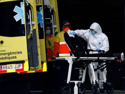Un técnico sanitario desinfecta la camilla de una ambulancia en la entrada de urgencias del Hospital de Bellvitge.