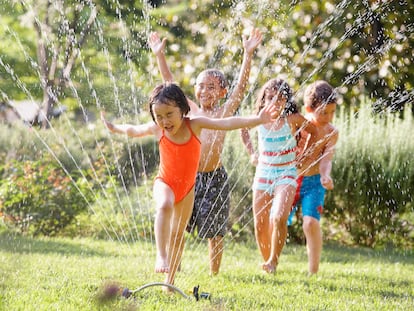 El verano es una época para el disfrute de los niños, afirman los expertos. Aquí, varios de ellos juegan con un aspersor.