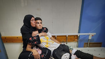 Una mujer abraza a un joven herido en el ataque israelí a una escuela de la UNRWA en Jan Yunis el martes.