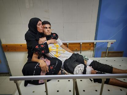 Una mujer abraza a un joven herido en el ataque israelí a una escuela de la UNRWA en Jan Yunis el martes.