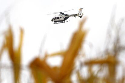 A police helicopter flies over the countryside around El Salobral.