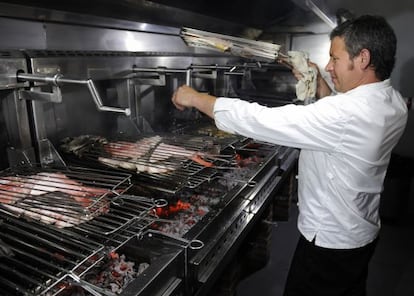 El cocinero Abel &Aacute;lvarez sala pescado a la parrilla en su restaurante.