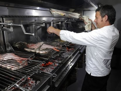 El cocinero Abel &Aacute;lvarez sala pescado a la parrilla en su restaurante.