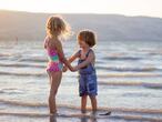 Dos niños juegan en la orilla del mar. 