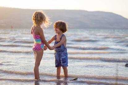 Dos niños juegan en la orilla del mar.