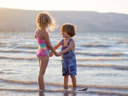 Dos niños juegan en la orilla del mar.