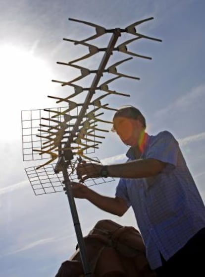 Un técnico instalando una antena de televisión.