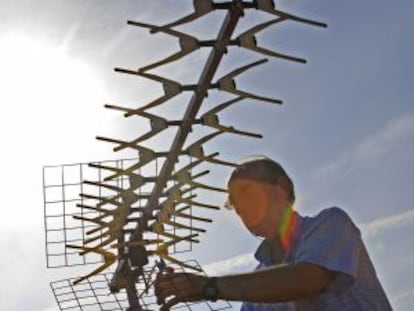 Un técnico instalando una antena de televisión.