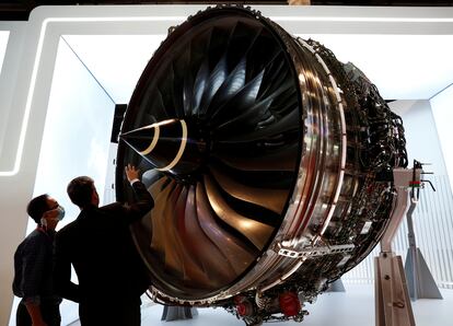 Dos personas miran un motor de Rolls-Royce que se muestra en el Salón Aeronáutico de Singapur, el 11 de febrero.