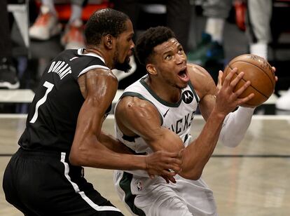 Antetokounmpo hace jugada y Durant intenta frenarle.