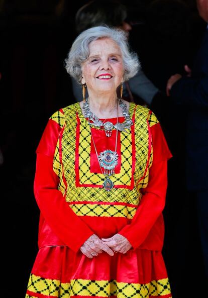 Elena Poniatowska posa para la prensa a su llegada al paraninfo de la Universidad de Alcalá de Henares. La escritora llevaba un traje rojo y dorado, regalo de las mujeres de Juchitán, un collar de plata y pendientes con forma de pez en oro.