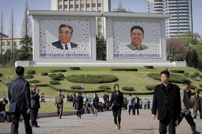 Muchos norcoreanos caminan por el centro de Pyonyang, donde se encuentran los retratos de los últimos líderes, Kim Il Sung (i) y Kim Jong Un (d).