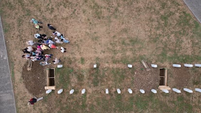 Vista de dron de varias personas cerca de una de las tumbas excavadas para el funeral conmemorativo, en el Centro Memorial de Srebrenica-Potocari en Potocari, Bosnia y Herzegovina.