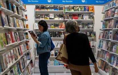 Visitantes recorren los pasillos de la FIL y compran libros.