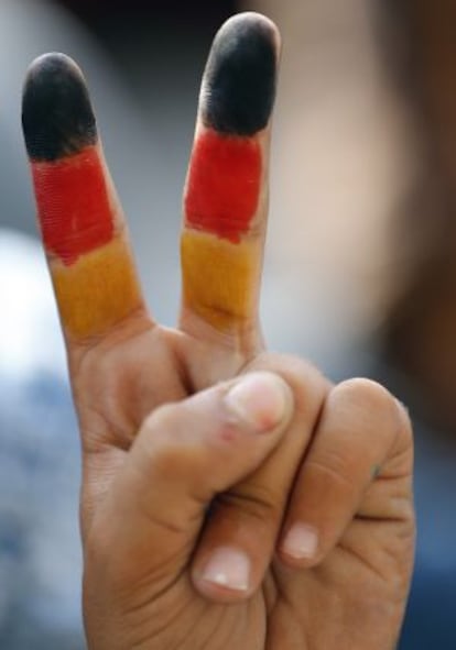 Colores de la bandera alemana pintados en la mano de un niño que aguarda en la estación de tren de Budapest.