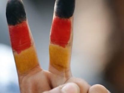 Colores de la bandera alemana pintados en la mano de un niño que aguarda en la estación de tren de Budapest.