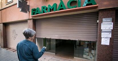 Una farmàcia amb la persiana abaixada en senyal de protesta.