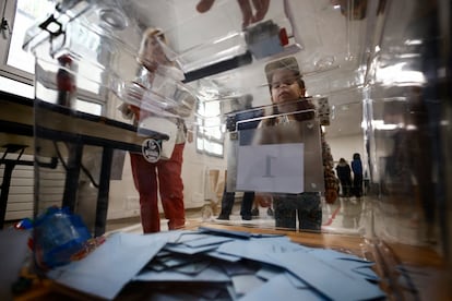Un niño mira las urnas con sobres dentro durante la segunda vuelta de las elecciones parlamentarias anticipadas francesas, en un colegio electoral en París.