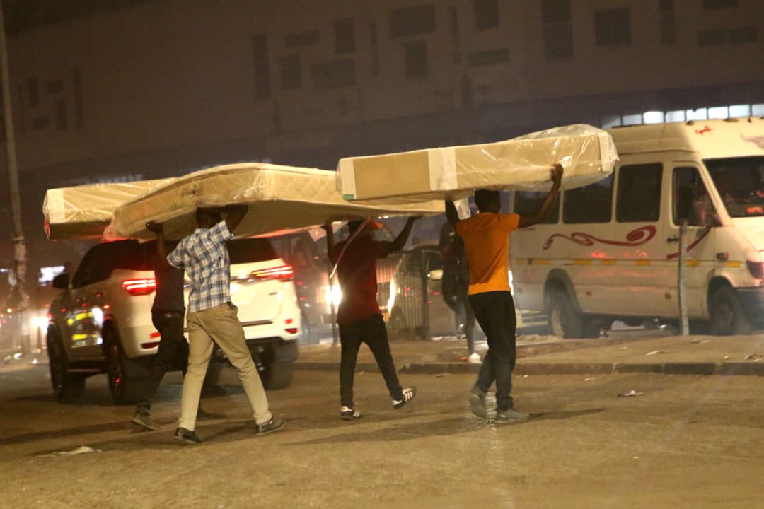 Cuatro hombres transportan camas por la calle Kenneth Kaunda, en el centro de Harare.