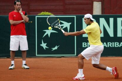 El capitán del equipo español de la Copa Davis, Albert Costa, observa a Rafael Nadal en su primer entrenamiento en la plaza de toros de Los Califas, escenario de la semifinal de la Copa Davis entre España y Francia.