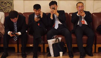 El uso del móvil para pagos en China se ha disparado. En la foto, varias personas consultan sus dispositivos durante el último congreso del Partido Comunista.
