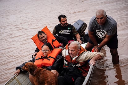 Personas evacúan una zona inundada por fuertes lluvias.