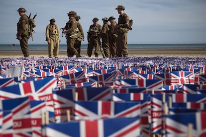 Un grupo de actores, vestidos con el uniforme de los soldados británicos en la playa Gold en Normandía.