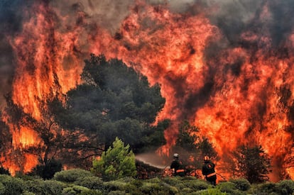 Los bomberos tratan de apagar el fuego en Kineta, cerca de Atenas, el 24 de julio de 2018.