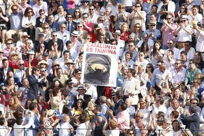 Un grupo de aficionados muestra una pancarta en la Maestranza de Sevilla.