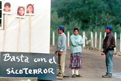 Dos miembros de Colonia Dignidad junto a las fotografías de niños víctimas de abusos sexuales.