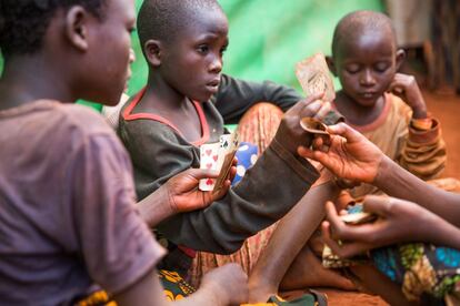 Niños jugando a las cartas en el campamento de refugiados de Nyarugusu. Este lugar es uno de los que cuenta con 'Espacios amigos de la infancia' de Plan Internacional para que los pequeños puedan divertirse y hablar de las dificultades que están atravesando.