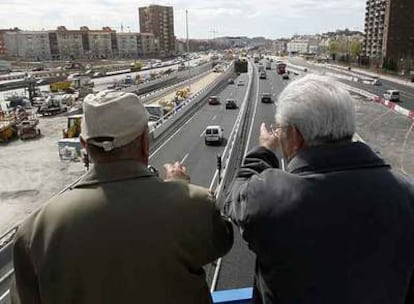 Dos vecinos observan desde un puente la entrada del túnel norte del <i>bypass</i> sur de la M-30, el más largo de Europa.