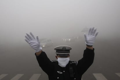 Un policía de tráfico se protege de la contaminación en la ciudad china de Harbin, en una imagen de archivo de octubre de 2013.