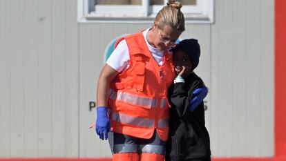 Una trabajadora de los equipos de emergencia consuela a un niño llegado en cayuco con otras 70 personas a la isla canaria de El Hierro.