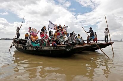 Ídolos de dioses hindúes son transportados en bote a través del río Ganges a plataformas temporales por el festival de Durga Puja en Calcuta (India).