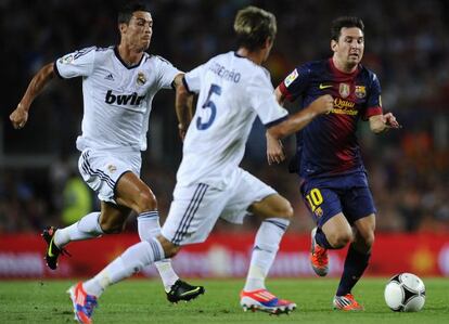 Messi, perseguido por Cristiano Ronaldo y Coentrão durante el partido de ida de la Supercopa.