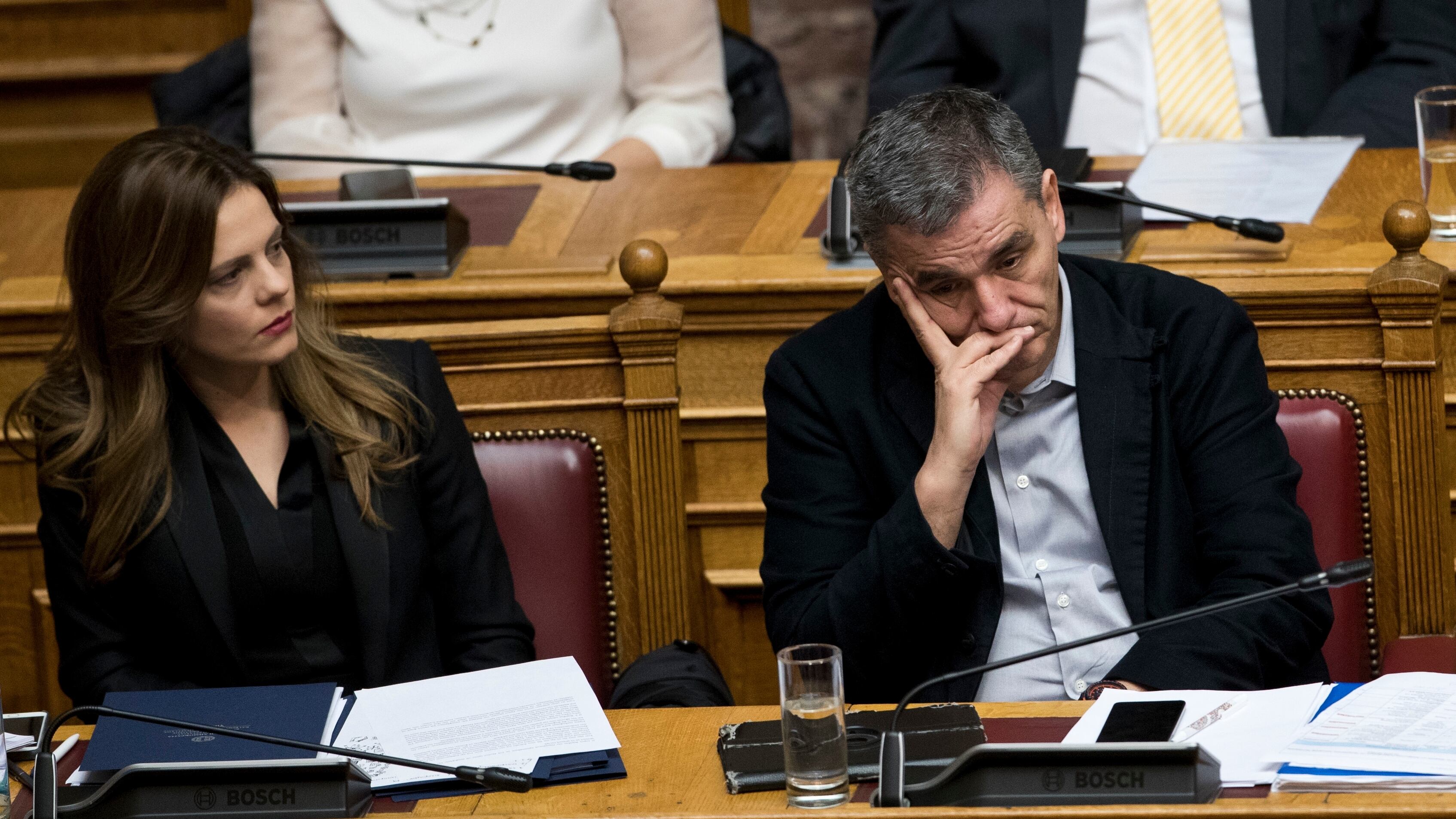 La ministra griega de Trabajo, Efi Ajtsioglu, a la izquierda, el ministro griego de Finanzas, Euclidis Tsakalotos, asisten a una sesión del Parlamento en Atenas, el lunes 15 de enero de 2018.