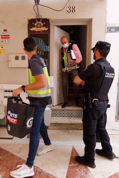 Agentes de la Policía Nacional salen de la vivienda de la calle San Ginés, en Torremolinos (Málaga), donde se ha localizado el cadáver de la mujer.