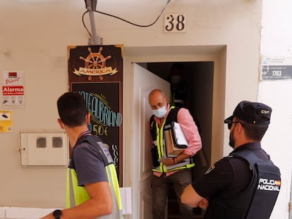 Agentes de la Policía Nacional salen de la vivienda de la calle San Ginés, en Torremolinos (Málaga), donde se ha localizado el cadáver de la mujer.