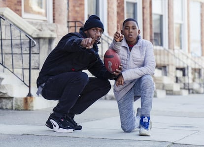 Kevin y su hijo Kemontae Spears posan con un balón de fútbol.