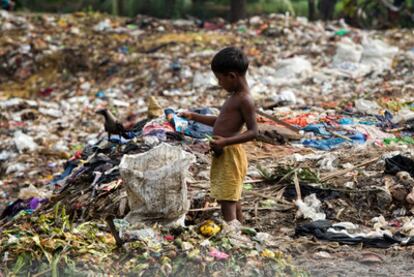 Disputa con un cuervo. Un niño de la calle se disputa con un cuervo un trozo de comida en un vertedero de la ciudad de Chittagong, al sur de Bangladesh.