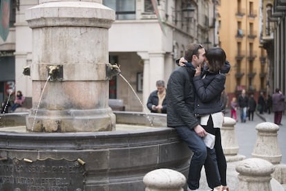 Una pareja de turistas se besa en la fuente del torico en Teruel, hoy, día de San Valentín.