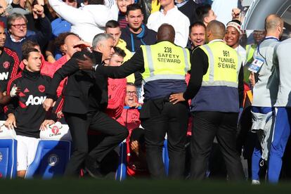 Los guardias de seguridad de Stamford Bridge frenan a Mourinho.