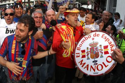 Manolo el del Bombo comparte el ambiente festivo, a las puertas de Mestalla, con aficionados del Barça y del Madrid.