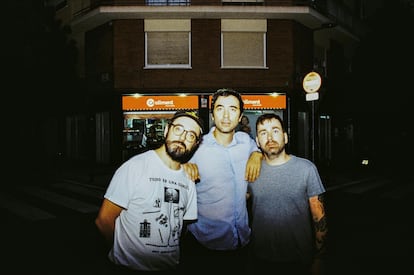 Rodellar, Alcover y Sanz, fotografiados frente a una tienda de alimentación en Barcelona. El primero de ellos lleva una camiseta de Confecciones Rodellar, diseñada por él mismo.