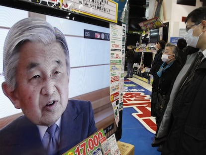 La clientela de una tienda de electrónica en Tokio escucha el discurso del emperador.